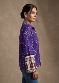 Side view of a woman wearing a purple printed shirt with full sleeves and ethnic border cuff detailing.