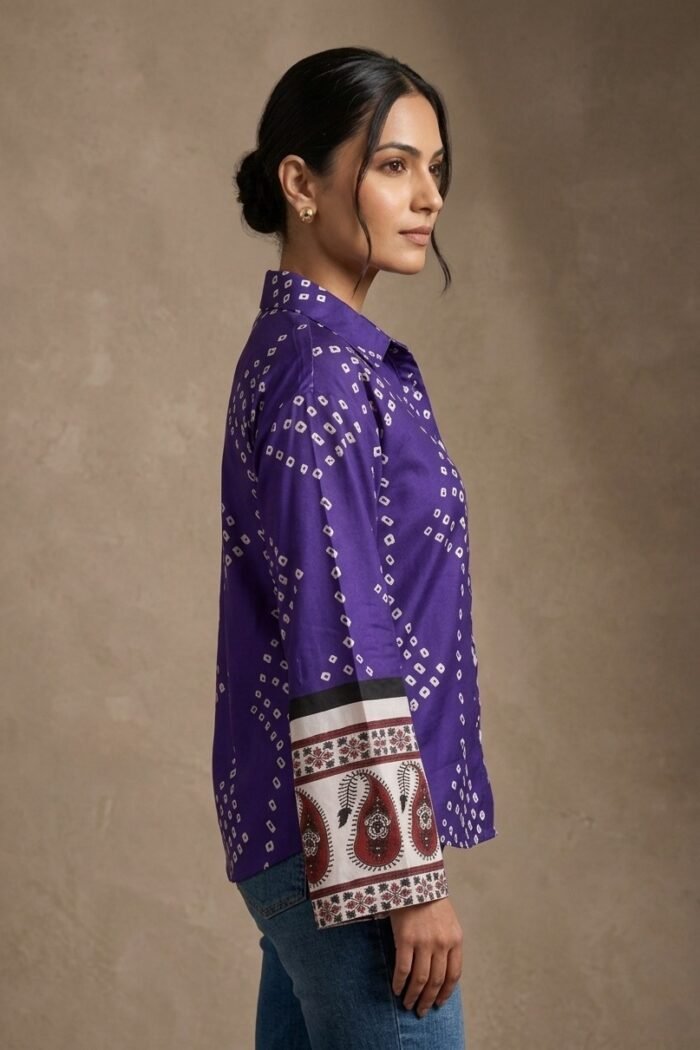 Side view of a woman wearing a purple printed shirt with full sleeves and ethnic border cuff detailing.