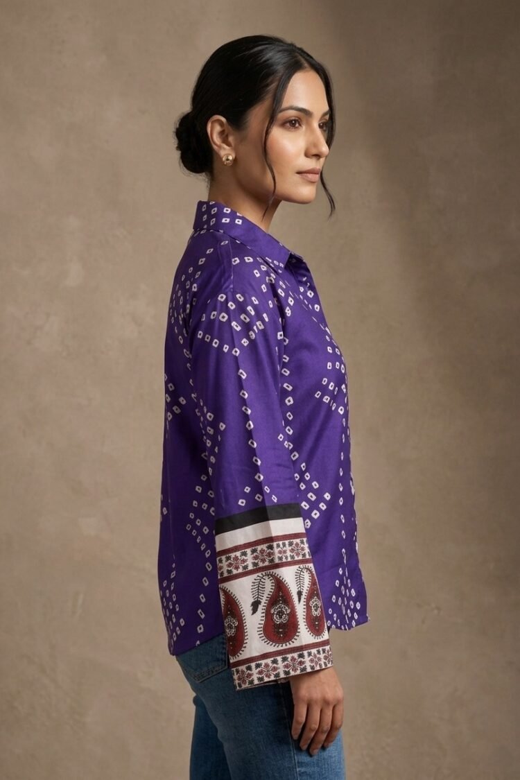 Side view of a woman wearing a purple printed shirt with full sleeves and ethnic border cuff detailing.