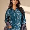 Women’s teal blue printed bell sleeve shirt with geometric pattern and button-down front paired with denim jeans.