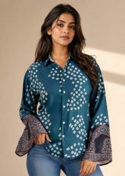 Women’s teal blue printed bell sleeve shirt with geometric pattern and button-down front paired with denim jeans.