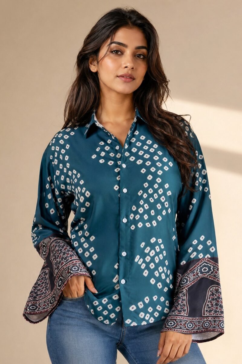 Women’s teal blue printed bell sleeve shirt with geometric pattern and button-down front paired with denim jeans.