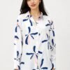 Women's white printed shirt featuring abstract navy blue and blush pink floral motifs, full sleeves, button-down front, and a relaxed fit, styled with dark blue denim jeans.