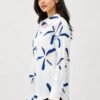 Side view of a women's white printed shirt with abstract navy blue and blush pink floral motifs, featuring a collared neckline, full sleeves, and a relaxed fit silhouette.